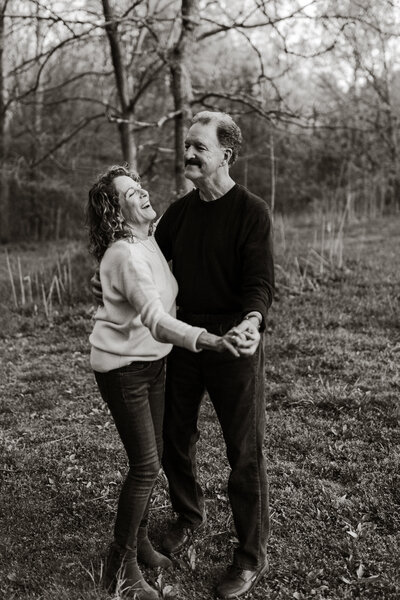 A black and white photo of an older couple dancing together in a park