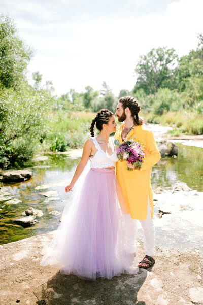 Bride and groom standing in low water river