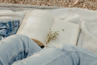 book laying on white blanket on the ground