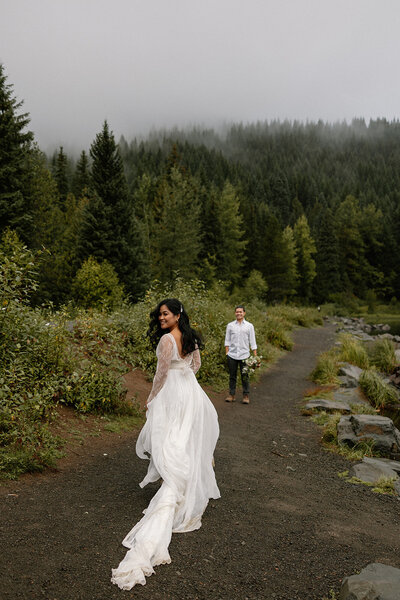 Bride runs toward her groom along the oregon mountains.
