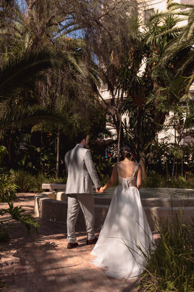 Wedding photographer captures couple taking a stroll hand in hand at their french chateau wedding.