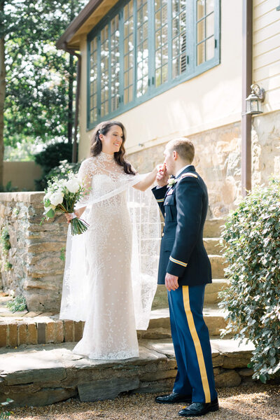 Groom kissing bride's hand on the steps at The Red Fox Inn and Tavern. Taken by Washington DC Wedding Photographer Bethany Aubre Photography.