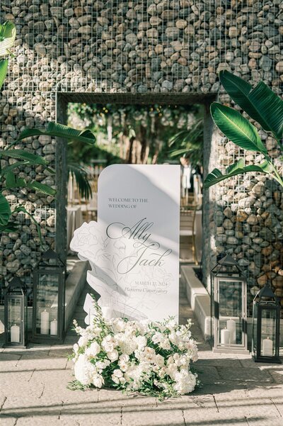 A black and white custom wedding invitation suite featuring a debossed invitation with wedding rings on it and a details and RSVP card by alyssa amez design custom wedding stationery and signage designer against a white background.