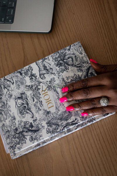 Hand on a Dior notebook
