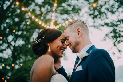 bride in white dress with veil and metal flower crown tears up after first kiss with groom in blue tux at terrain in glen mills shot by philadelphia wedding photographer alex medvick