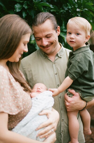 Newborn Portrait taken in home in St Augustine near Jacksonville with the family snuggling and smiling at their baby