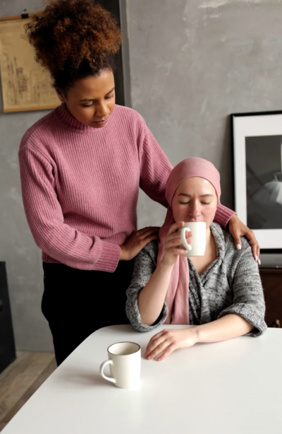 Woman comforting another women drinking cofrfee