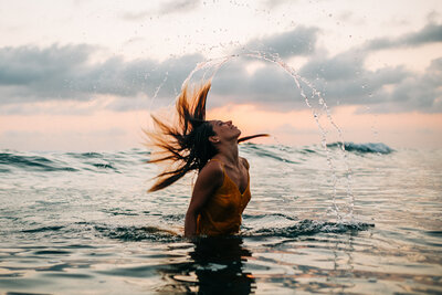 Girl with long hair does a hair flip in the ocean at South Padre Island