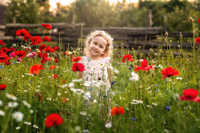 Full of color, joy, and sunshine, this outdoor milestone portrait captures a little girl’s delight in a blooming wildflower field.