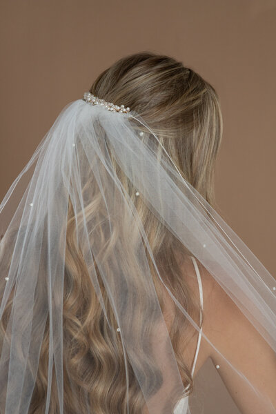 bride wearing a pearl veil and hair comb with pearls and crystals