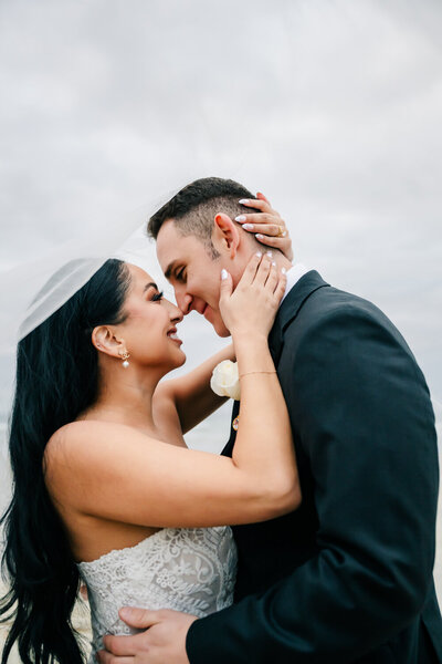 bride and groom embracing while smiling