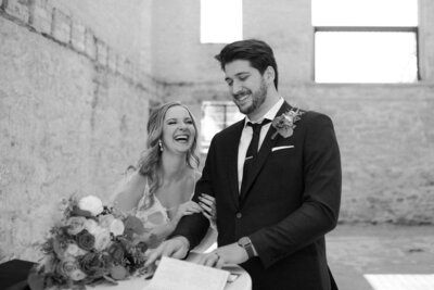 black and white image bride and groom laughing