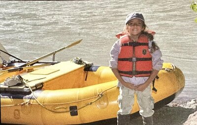 Me at 9 years old in a life vest in front of a raft, before an adventure in Alaska