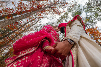 View from below of a newlywed couple holding hands 