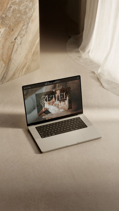 A laptop with a website design for an elopement and wedding photographer