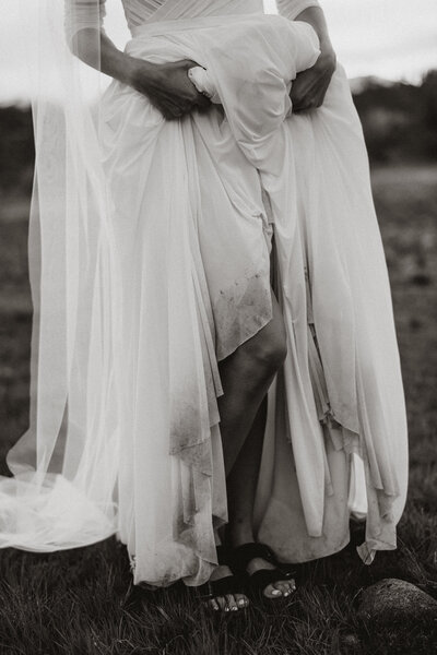 Close-up of bride’s muddy wedding dress hem, captured by Breckenridge elopement photographer in the mountains.