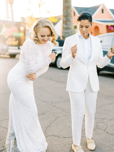 LGBTQ couple dances in the street both women are wearing white