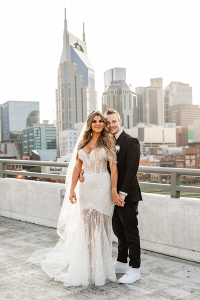 Bride and groom standing on a balcony with skyscrapers behind them