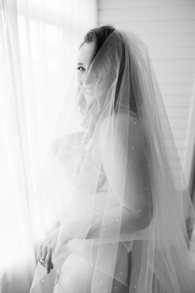 woman in veil posing for bridal boudoir photos