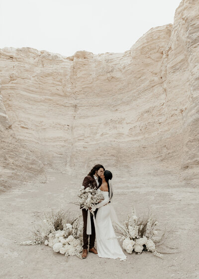 bride and groom almost kissing and holding floral bouquet