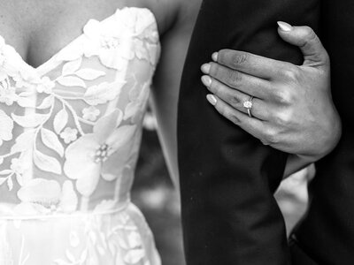 A bride's hand on the groom's arm. 