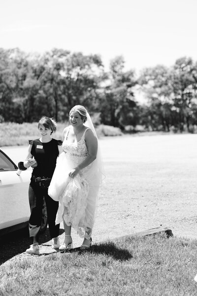 Wedding planner assisting with dress train at The White Barn in Wichita, KS 