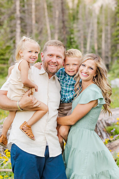 Family of 4 posing together during their summer family session in the Snowy Range Mountains near Laramie, Wyoming.
