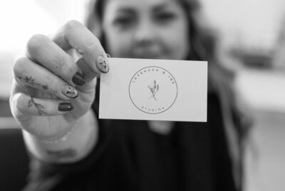 Owner, Ingrid, holding Lavender & Ink Studios business card in New Franken, WI.