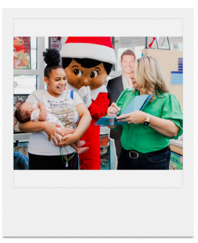 Polaroid photo of Chanda with child and Scout Elf mascot