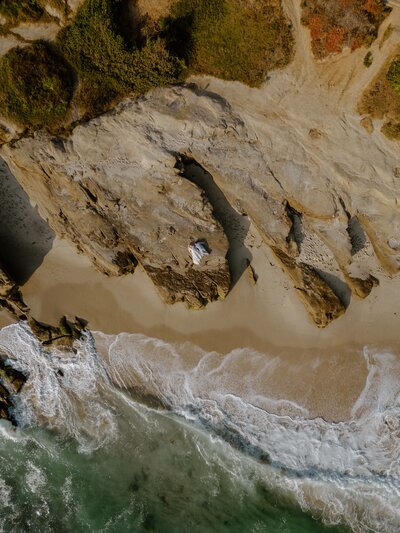 bride and groom on sand cliffs captured by drone