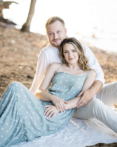 engaged couple embracing on ground