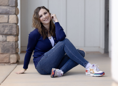 woman wearing blue sitting on ground smiling