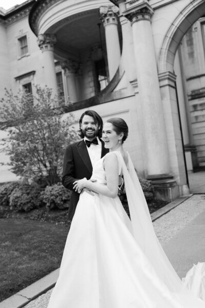 Bride and groom smiling together in front of the historic Larz Anderson House in Washington, D.C., showcasing its Beaux-Arts architecture and elegant surroundings.