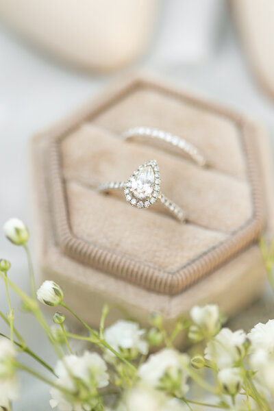 Tear shaped diamond wedding ring in light pink velvet ring box.