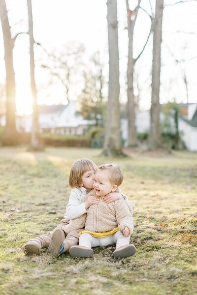 Toddler boy kisses baby girl's cheek in Maryland family session.