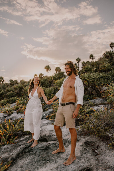 bride and groom hold hands at the beach