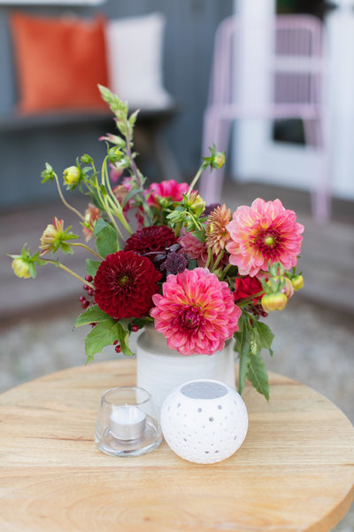 small burgundy and light pink florals in a round ceramic vase. 