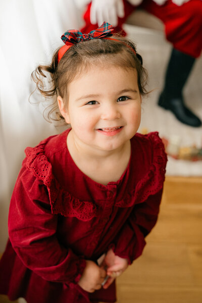 A little girl smiling to see Santa Claus.
