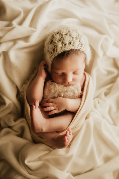 Newborn girl swaddled and posed on a cream blanket in Yukon Oklahoma