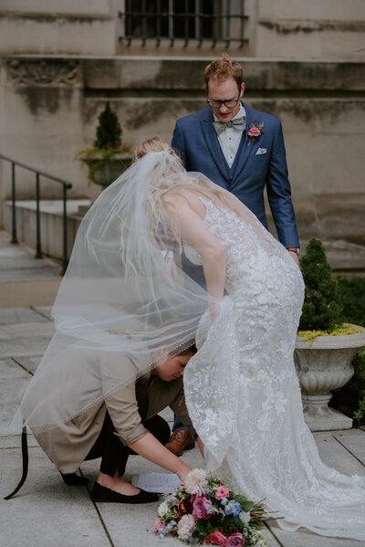 Kaitlin tying Bride's shoe