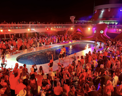 Virgin Voyages pool party with everyone dancing around the ship pool dressed in red.