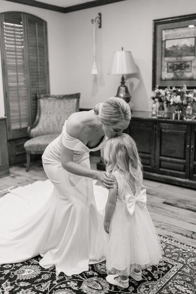 bride kissing flower girl on forehead