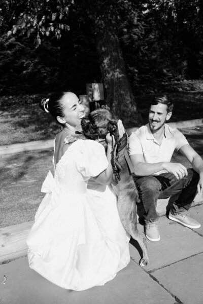 Bride and groom share candid moment with dog during their welcome party at their New Jersey destination wedding weekend. 