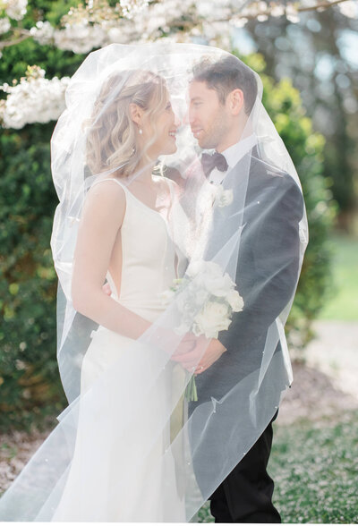 Bride and Groom under veil at Market at Grelen in Charlottesville, Virginia. Captured by Charlottesville Wedding Photographer Bethany Aubre Photography.