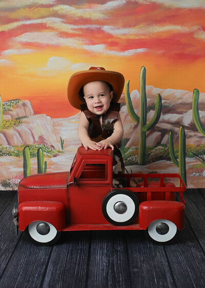 Cute cowboy posing for his denver cake smash photographer session.