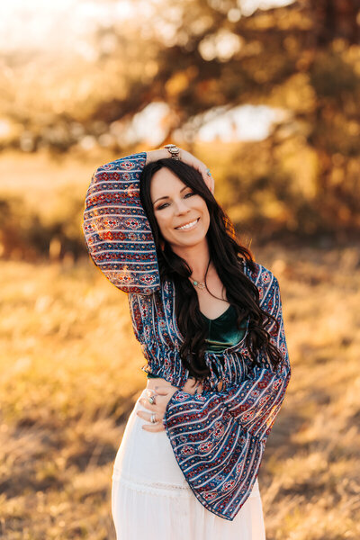 Owner of Annie Bee Photographer posing for headshots at Lake Mary at sunset.