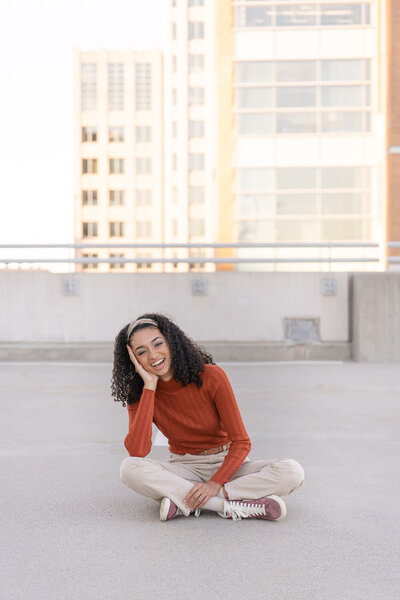 girl sitting in parking garage during Reston, VA senior photos