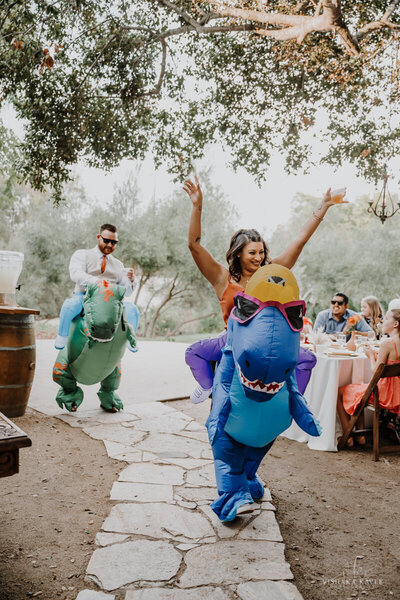 bridesmaid and groomsman wearing trex costumes during wedding reception