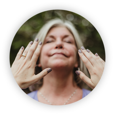 person with silver hair and eyes closed smiling and hands reaching toward her