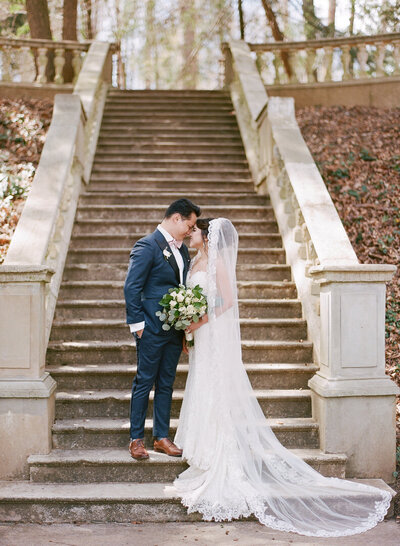 Bride and Groom Nose to Nose on Steps at Cator Woolford Gardens in Atlanta Georgia photo